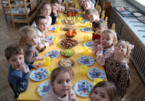 dzieci siedzą przy stole urodzinowym