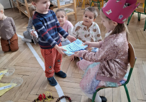 chłopiec wręcza dziewczynce w różowej koronie, laurki