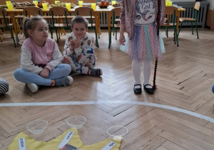 ziewczynka w różowej koronie trzyma sznurek z koralami