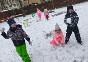 dzieci trzymają w dłoniech snieżne kule
