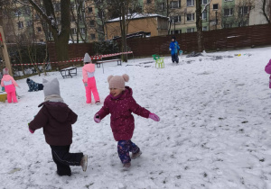 dzieci biegają po ogrodzie