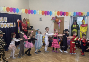 Dzieci udają pociąg i prezentują swoje stroje.