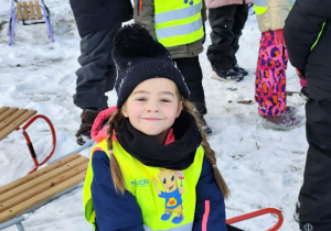 dziewczynka siedząca na sankach