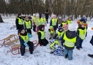 grupa dzieci słuchająca nauczyciela, który tłumaczy zasady gry w hokeja