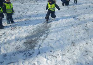 dzieci podczas ślizgania się na ślizgawce