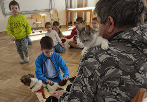 Dzieci głaszczące psa i kota