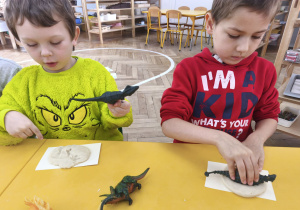 Dzieci wykonują odcisk dinozaura