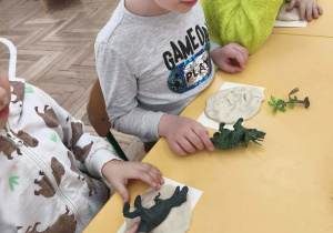 Dzieci wykonują odcisk dinozaura