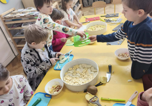 Dzieci obierają i kroją owoce