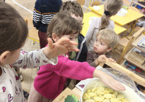 Dzieci sprawdzają jakie ciepło wydobywa sie z suszarki