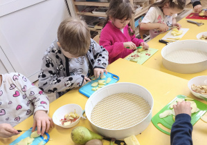 Dzieci obierają i kroją owoce