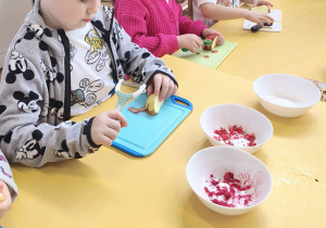 Dzieci obierają i kroją owoce