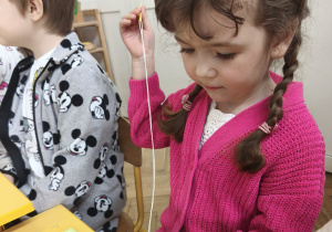 Dziewczynka nawleka owoce