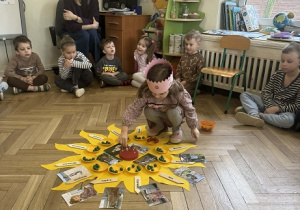 Zdjęcie przedstawia dziewczynkę podczas wkładania świeczek w tort urodzinowy.