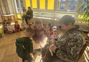 Zdjęcie przedstawia dzieci głaszczące zwierzątka.