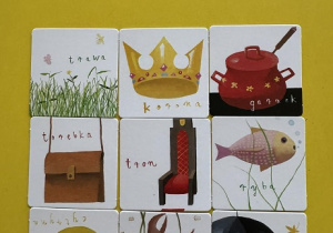 Zdjęcie przedstawia obrazki leżące na stole.