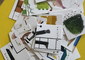 Zdjęcie przedstawia obrazki leżące na stole.