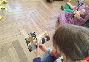 dziewczynka oglądająca zdjęcia przyniesione przez jubilata