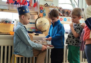 chłopiec częstujący dzieci babeczkami zrobionymi wspólnie z mamą