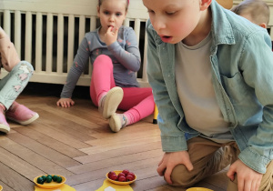 Na zdjęciu chłopiec w koronie dmucha świeczki