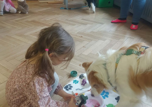 dziewczynka, która wlewa wodę pieskom do miski