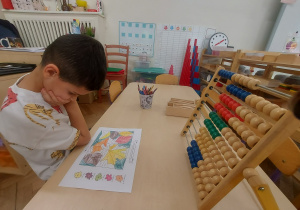 hm - ile to może być? chłopiec wykonujący działania matematyczne