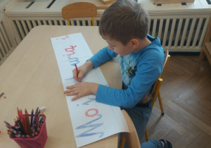 chłopiec tworzy napis z ruchomego alfabety