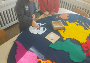 dwóch chłopców poznaje jakie zwierzęta żyją na danym kontynencie