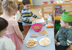 Dzieci częstują się słodyczami.