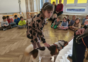 Dziewczynka głaszcze pieska.