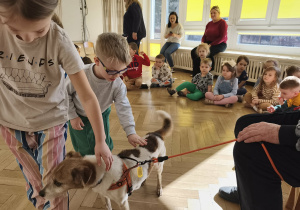 Dzieci głaszczą pieska.