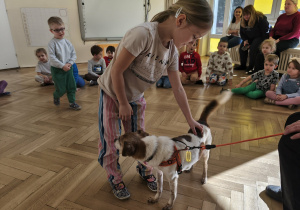 Dziewczynka głaszcze pieska.