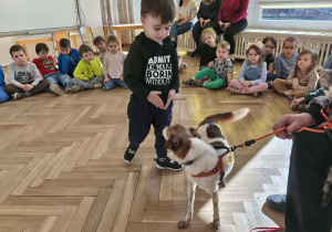 Chłopiec głaszcze pieska.