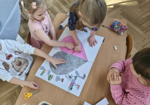 Na zdjęciu widzimy dzieci, które tworzą plakat.