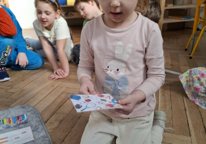 dziewczynka trzyma zdjęcie z symbolami sprtu