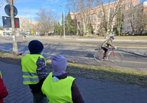 dzieci patrzą na rowerzystę