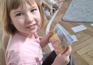 dziewczynka trzyma w rękach fotografię czystego krajobrazu