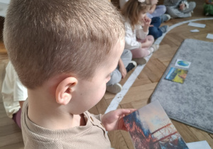 chłopiec patrzy na fotografię płonącego lasu