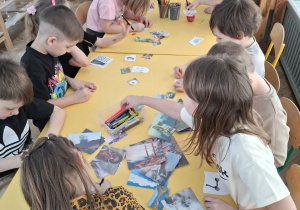 dzieci przy stoliku kolorują obrazki