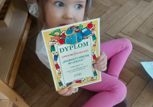 Na zdjęciu dziewczynka z otrzymanym dyplomem