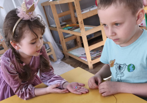 Chłopcy wykonujący bransoletki w parze z koleżanką