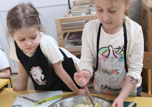 Dzieci mieszają i doprawiają sałatkę