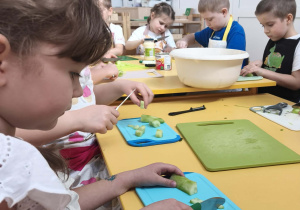 Dzieci obierają i kroją ogórki