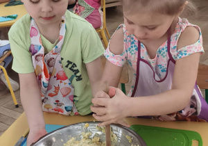 Dzieci mieszają i doprawiają sałatkę