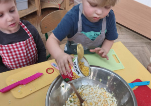 Dzieci mieszają i doprawiają sałatkę