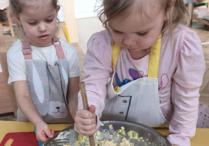 Dzieci mieszają i doprawiają sałatkę
