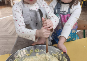 Dzieci mieszają i doprawiają sałatkę