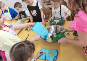 Dzieci wrzucają pokrojone produkty do miski