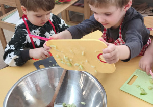 Dzieci wrzucają pokrojone produkty do miski