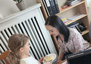 Dziewczynka przekazuje porcje sałatki Pani dyrektor do degustacji